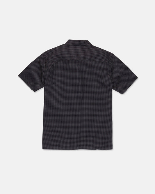 A Volcom Men's Glasnow Short Sleeve Shirt, featuring a small yarn-dyed checkered pattern in dark colors and made from cotton, is laid flat with the back side visible against a white background.