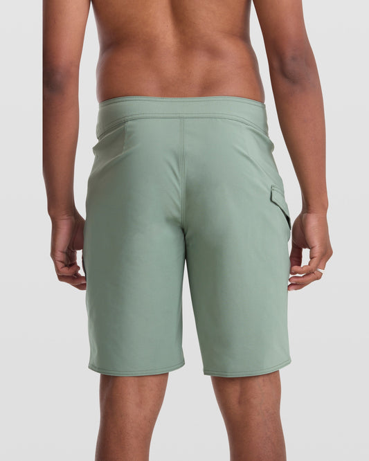 A person wearing Volcom Men's Lido Solid 20" Trunks with 4-way stretch fabric.