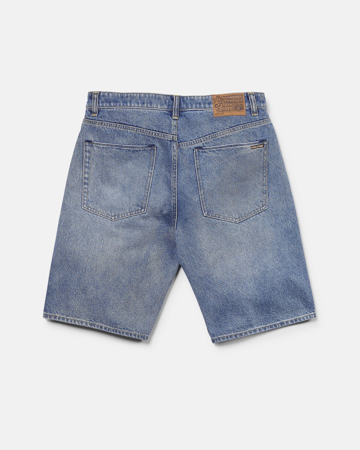 Back view of Volcom Men's Billow Denim Shorts in blue, featuring two large rear pockets, belt loops, and a brown leather patch on the waistband. These shorts offer a loose fit and a slightly faded look.