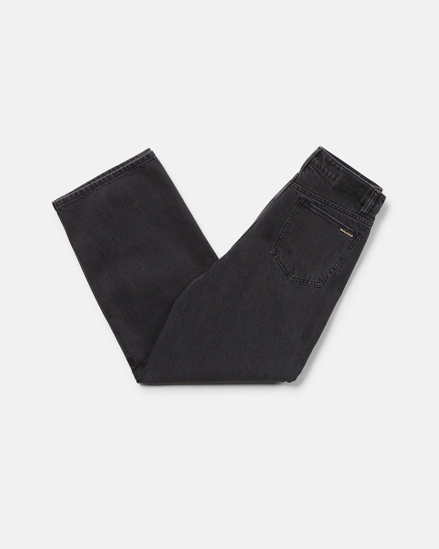 A pair of Volcom Boy's Big Boys' Billow Denim II Pants in black, folded neatly on a white background with the back pocket and waistband visible.