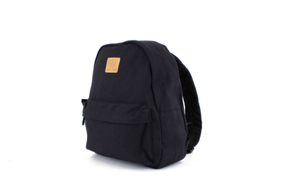 A side-angle view of the Volcom Women's Winnie Backpack in solid black, ideal for carrying your everyday essentials, featuring a tan square patch with the Volcom logo on the front, set against a plain white background.