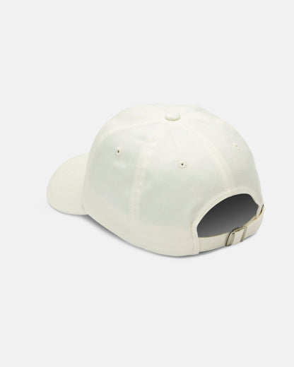 The Women's Stone Rising Hat by Volcom is displayed from the back, highlighting its adjustable metal-buckle strap. This unstructured 6-panel ivory cotton cap appears against a plain white background.