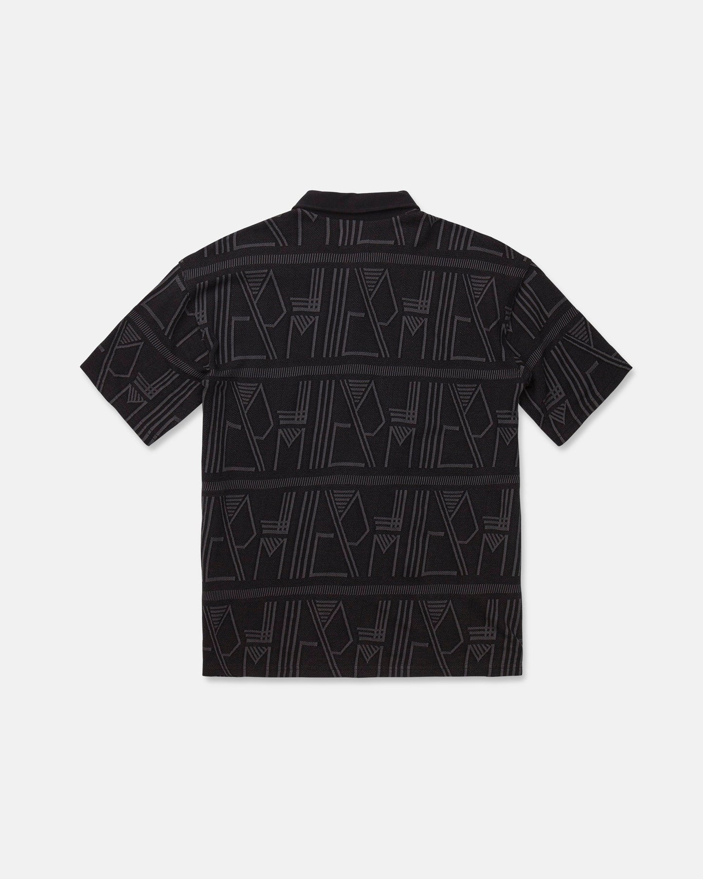 The Men's Stone Optix Polo by Volcom is a black short-sleeve shirt with an abstract geometric pattern in gray, featuring yarn-dyed jacquard lines and shapes across the fabric. Displayed flat to show the back side against a white background, this polo features a boxy fit.