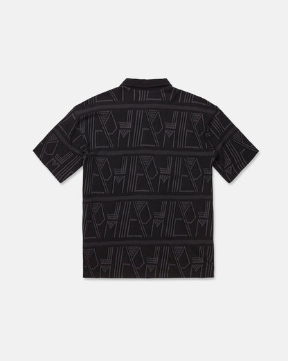 The Men's Stone Optix Polo by Volcom is a black short-sleeve shirt with an abstract geometric pattern in gray, featuring yarn-dyed jacquard lines and shapes across the fabric. Displayed flat to show the back side against a white background, this polo features a boxy fit.
