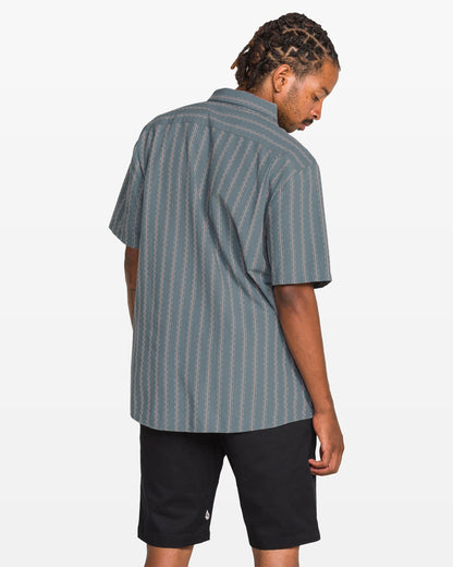 Man wearing a striped shirt and black shorts on a white background