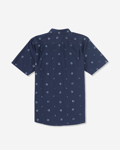 The Men’s Scaler Stone Woven Short Sleeve Shirt by Volcom is a navy blue collared shirt with an allover print of small white circular dots, shown from the back.