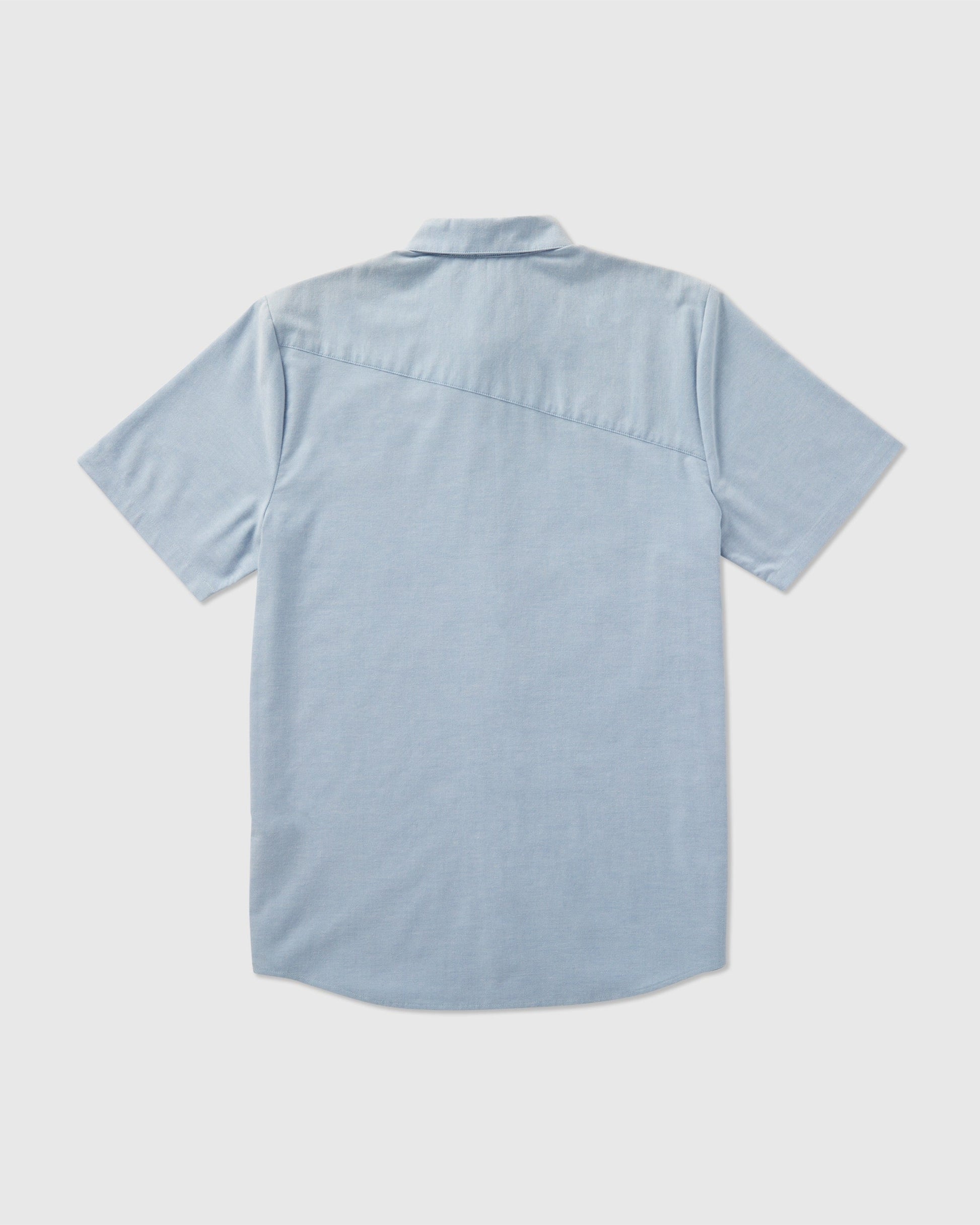 The Volcom Men's Everett Oxford Short Sleeve shirt in light blue has a slim fit, straight hem, and a distinctive diagonal seam across the upper back, combining classic and modern style.