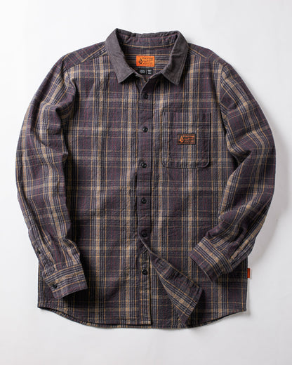 The Volcom Men's Stonevise Plaid Long Sleeve is a workwear-style flannel shirt with purple, gray, and beige plaid, chest pocket, small orange label, and button-up front. Displayed flat on a white background.