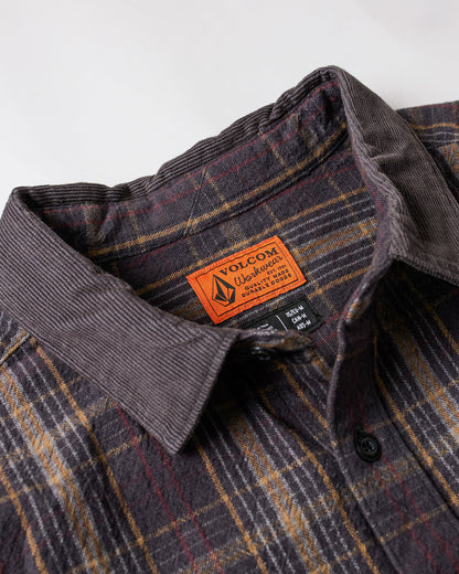 Close-up of Volcom’s Men's Stonevise Plaid Long Sleeve shirt with a corduroy collar and an orange Volcom label inside. The plaid pattern combines brown, yellow, and red shades.