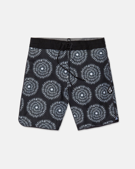 Men's Barnacle Stoney board shorts by Volcom, featuring a black base with a white and gray circular geometric pattern, a black drawstring waistband, and a small white Volcom logo on the left leg. Made from a comfortable hemp-cotton blend, these shorts are displayed flat on a white background.