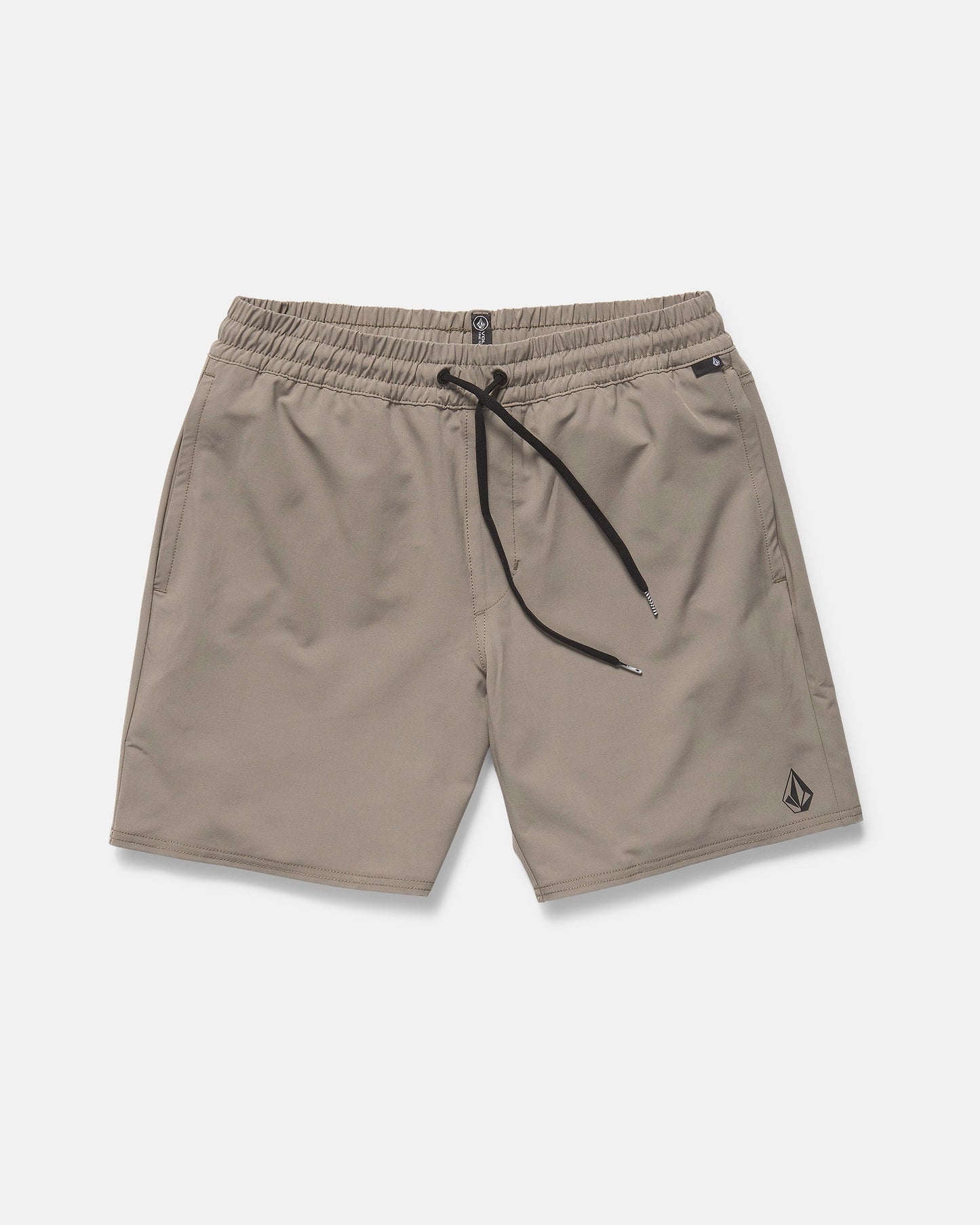 The Volcom Men's Nomoly Elastic Waist Shorts 18" in light brown feature a black drawstring, side pockets, 4-way stretch recycled polyester, and a small Volcom logo near the left hem. Displayed flat on a white background.