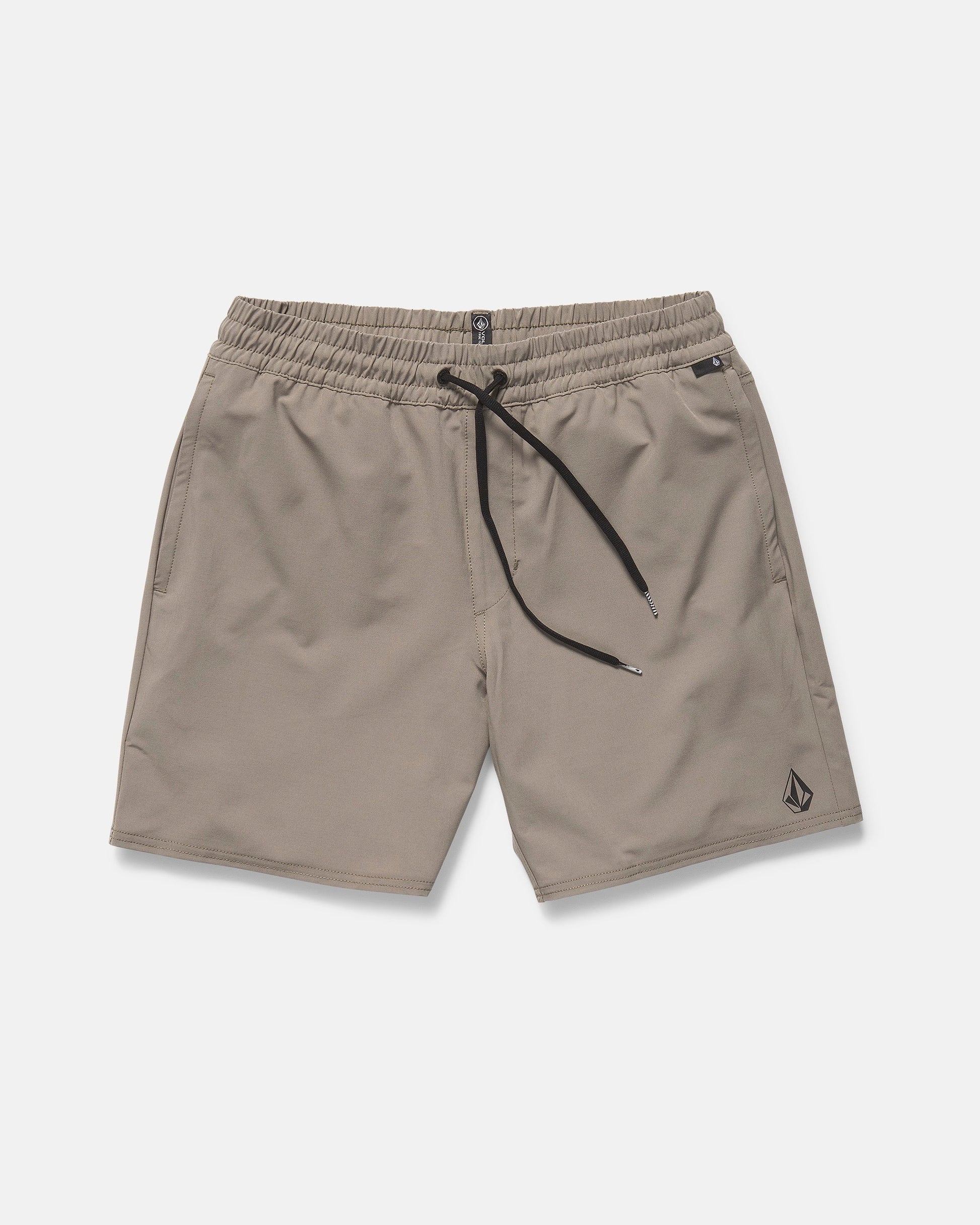 The Volcom Men's Nomoly Elastic Waist Shorts 18" in light brown feature a black drawstring, side pockets, 4-way stretch recycled polyester, and a small Volcom logo near the left hem. Displayed flat on a white background.