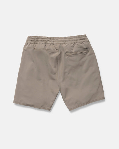 The Volcom Men's Nomoly Elastic Waist Shorts 18" in khaki are made from recycled polyester with 4-way stretch, featuring two side pockets and a zippered back pocket. Shown laid flat from the back on a white background.