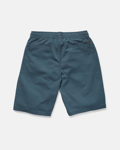 The rear view shows Volcom Men's Freazy Loose Elastic Waist 22" Shorts in blue-green corduroy with a 22-inch outseam, two back welt pockets, and a stitched logo tag on the right pocket against a plain white background.