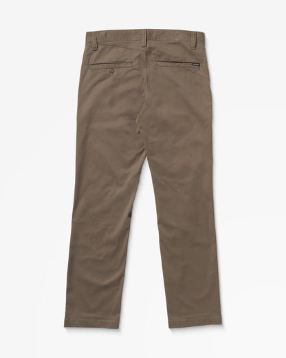 A pair of brown chinos laid flat, viewed from the back, featuring belt loops, two back pockets—one with a button—and a small brand tag above the right pocket.