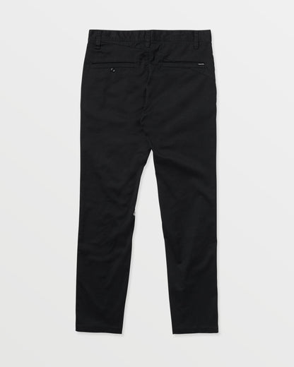 The Volcom Men's Frickin Modern Stretch Pants are black chinos shown laid flat on a white background, back view, featuring two rear pockets and belt loops, crafted with REPREVE recycled fibers for eco-friendly comfort.