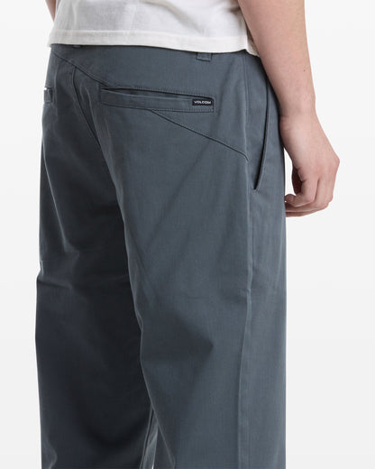 A man, seen from behind at an angle, wears a white shirt and gray Volcom Men's Frickin Modern Stretch Pants.