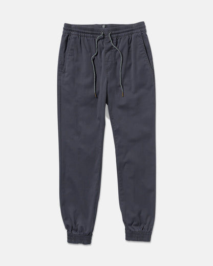 The Volcom Men's Frickin Slim Joggers in dark gray feature REPREVE recycled fibers, an elastic waistband with drawstring, side pockets, and elastic cuffs, shown laid flat on a white background.