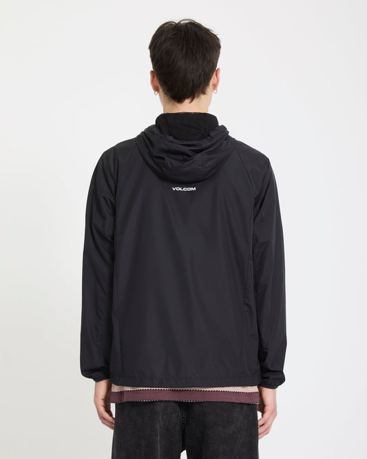 A person with short dark hair, wearing the Volcom Men's Wavern Jacket with a logo on the back, stands facing away from the camera against a plain white background.