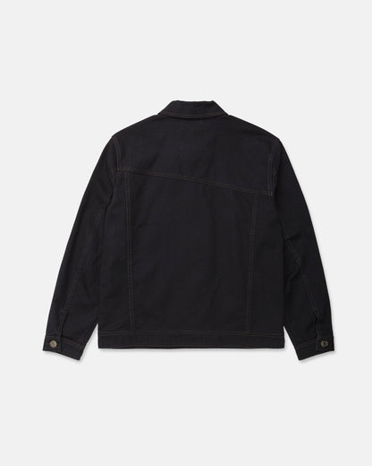 The Men's Slakers Jacket by Volcom is pictured from the back in black denim, showcasing long sleeves, brown stitching, a straight hem, and buttoned cuffs. Designed as a lightweight jacket, it is set against a plain white background.