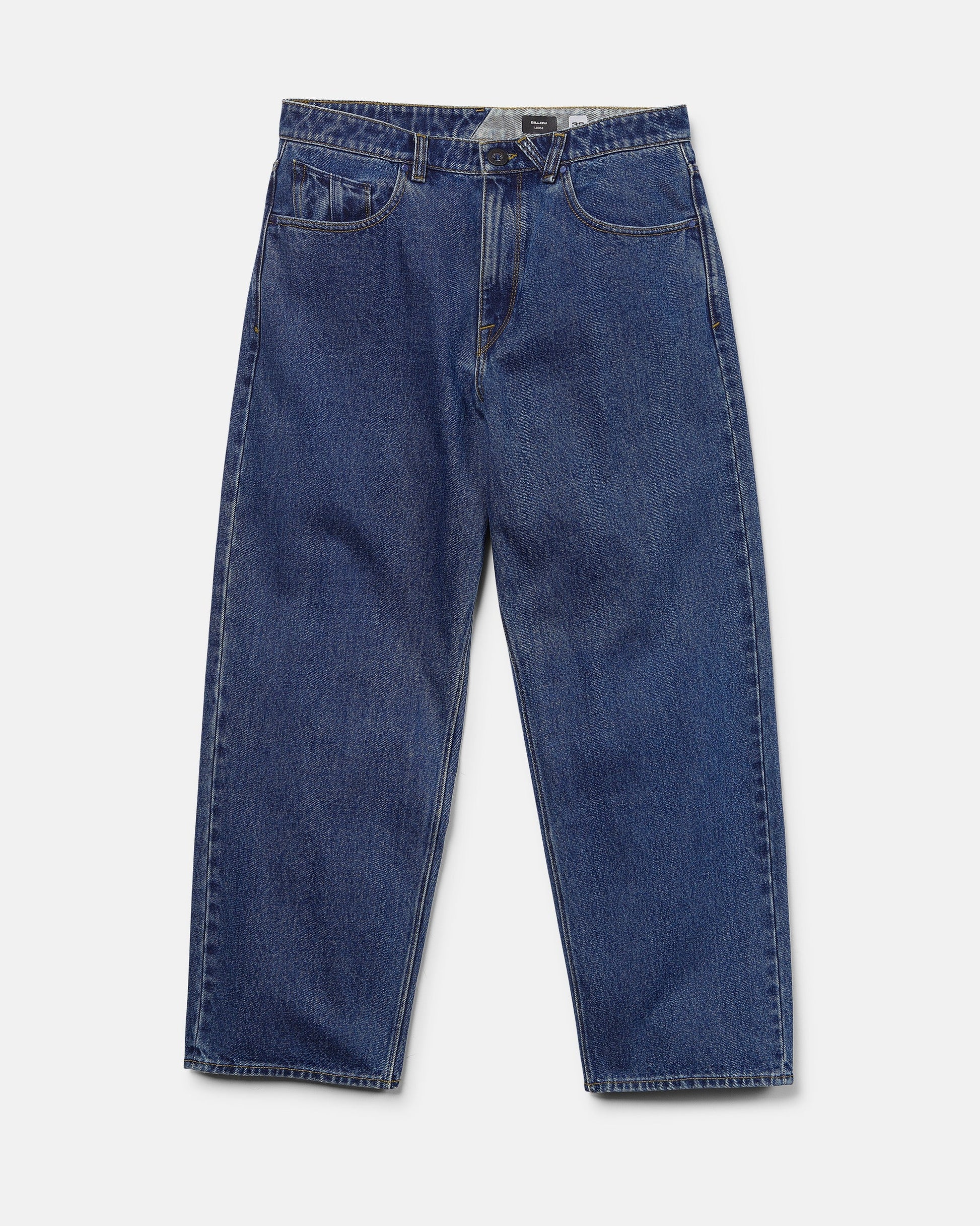 The Men's Billow Denim Pants by Volcom are a pair of loose fit, low rise jeans in a rich dark indigo wash, featuring a classic five-pocket design, button closure, and straight legs, shown laid flat on a white background.