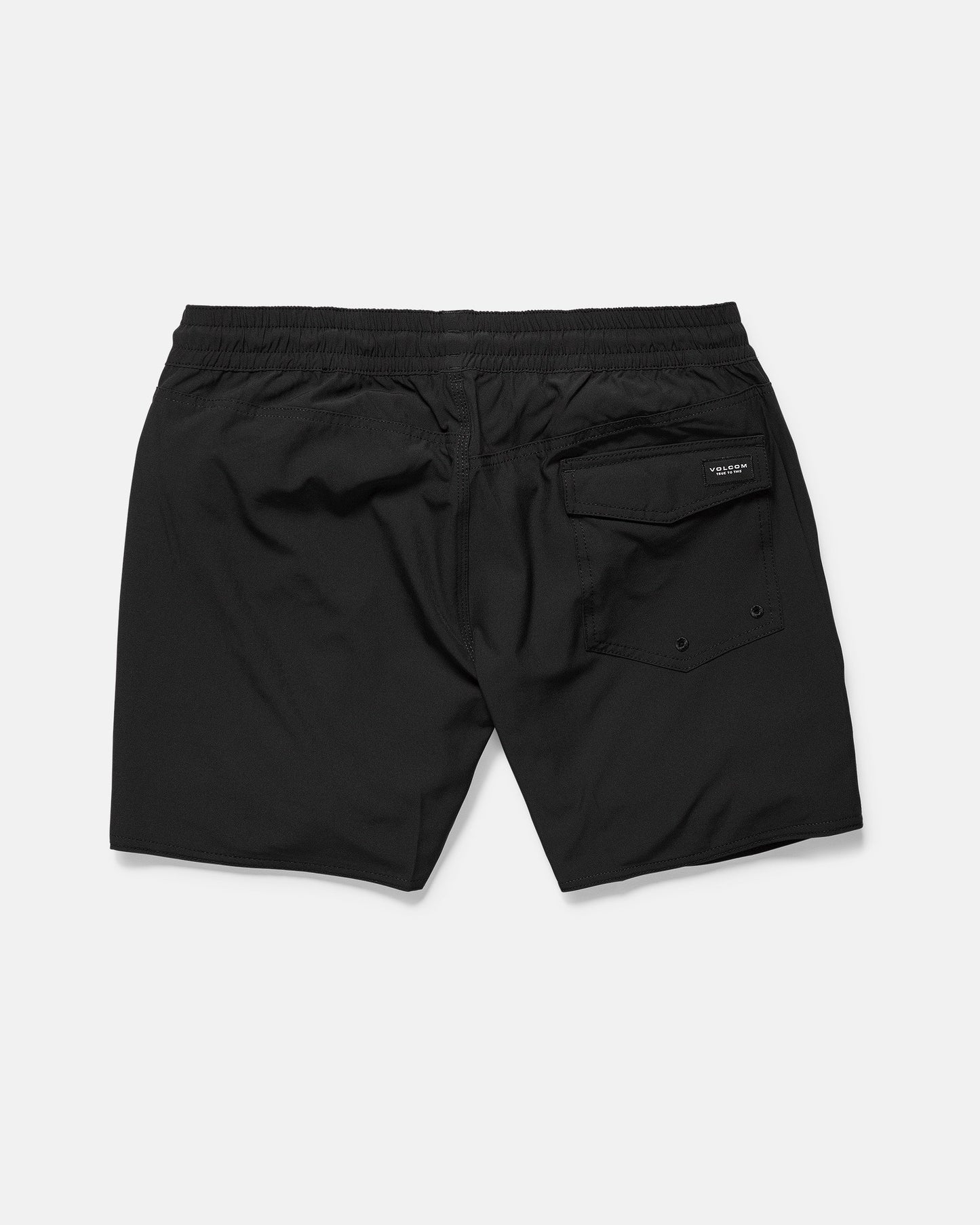 The Volcom Men's Lido 2 Solid Trunks, shown from the back on a white background, feature an elastic waistband, a right back flap pocket with button closure, and are made from recycled polyester with mechanical stretch.