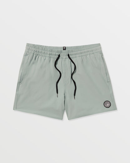 Volcom Men's Lido Solid 16" Trunks in light gray feature a black drawstring, two side pockets, and a small circular patch near the left hem. Made from recycled polyester with 2-way stretch, shown on a plain white background.
