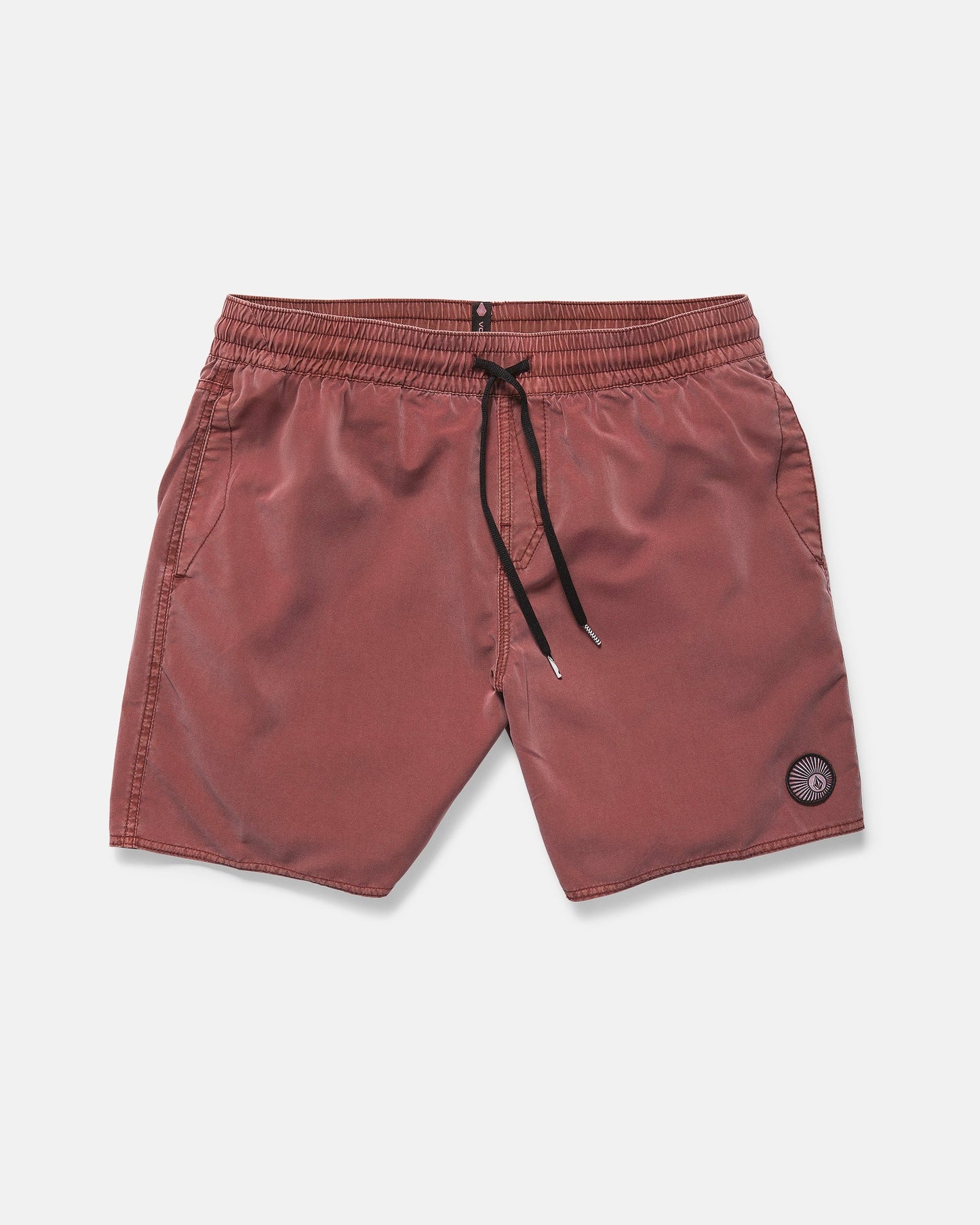 Volcom Men's Center Elastic Waist 17" Trunk swim shorts in red-brown, featuring mechanical stretch, side pockets, and a circular patch logo on the left leg, shown against a plain white background.