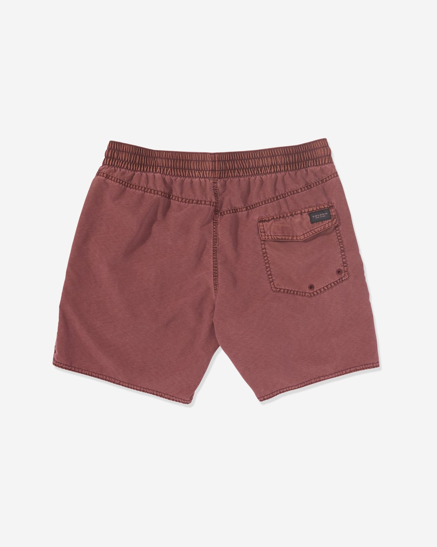 Back view of Volcom Men's Center Elastic Waist Trunks in maroon, featuring an elastic waist, right back pocket with a black label above it. Made from a polyester blend and shown laid flat on a white background.