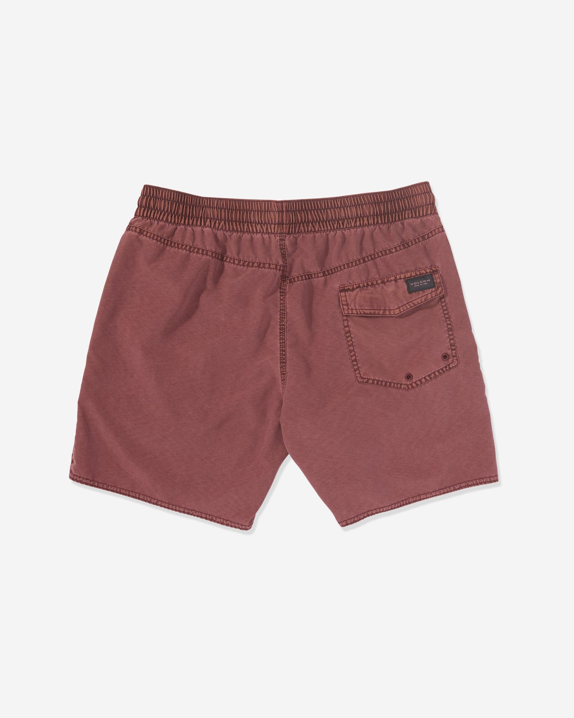 Back view of Volcom Men's Center Elastic Waist Trunks in maroon, featuring an elastic waist, right back pocket with a black label above it. Made from a polyester blend and shown laid flat on a white background.