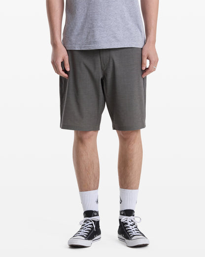A person models Volcom Men's Mix Frickin Cross Shred Shorts, paired with a gray t-shirt, white crew socks, and black-and-white sneakers against a white backdrop. The head is cropped out of the image.