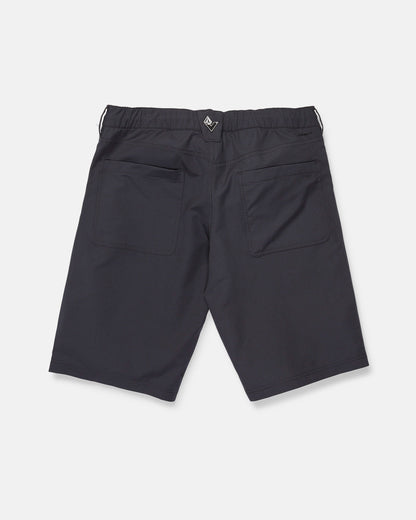 Back view of Volcom Men's Venture Stone Hybrid Shorts in Asphalt Black, crafted from recycled-poly fabric. The shorts feature two rear patch pockets, an elastic waistband, and a small black and white tag at the center back. Displayed against a plain white background.