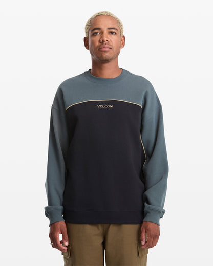 Man wearing a two-tone sweatshirt with 'Volcom' branding on a white background