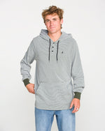 A young man wearing the Volcom Men's Rowan Thermal Long Sleeve Shirt in light gray, featuring black drawstrings, pairs it with blue jeans as he stands against a plain white background, looking at the camera with a relaxed expression.