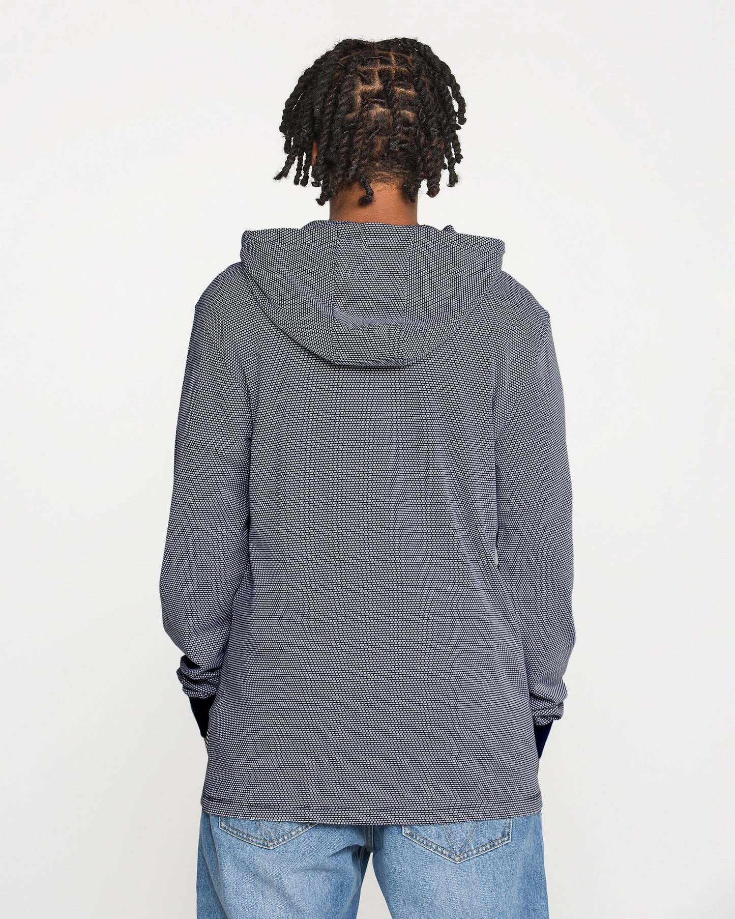 A person with short, twisted braids wears the Volcom Men's Rowan Thermal Long Sleeve Shirt in gray, paired with blue jeans, standing with their back to the camera against a plain white background.
