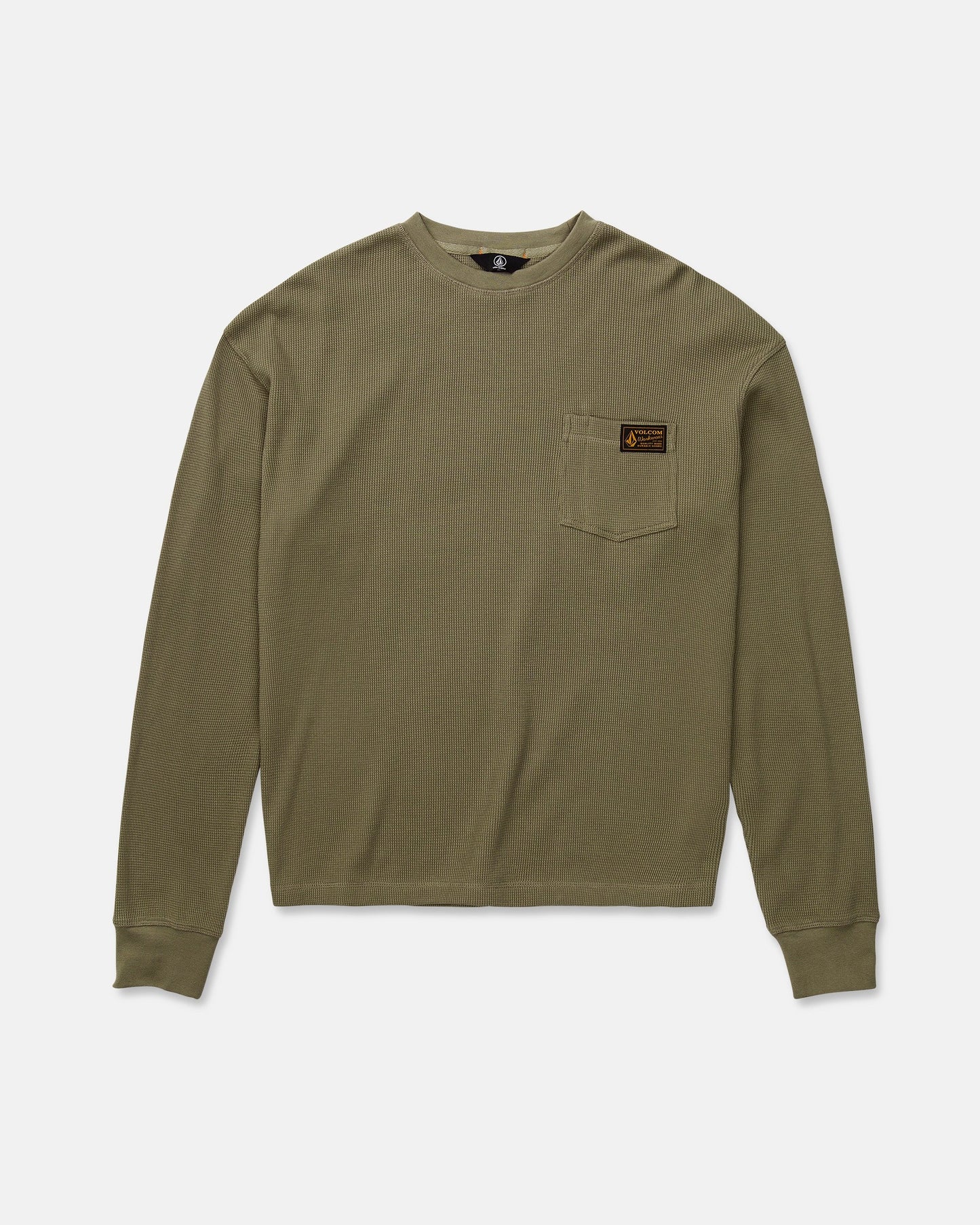 The Volcom Men's Overtime Workwear Thermal Long Sleeve Shirt in olive green is crafted from soft cotton knit for a classic thermal appeal. This shirt features ribbed cuffs, a small left chest pocket with a brown rectangular patch label, and is displayed laid flat on a white background.
