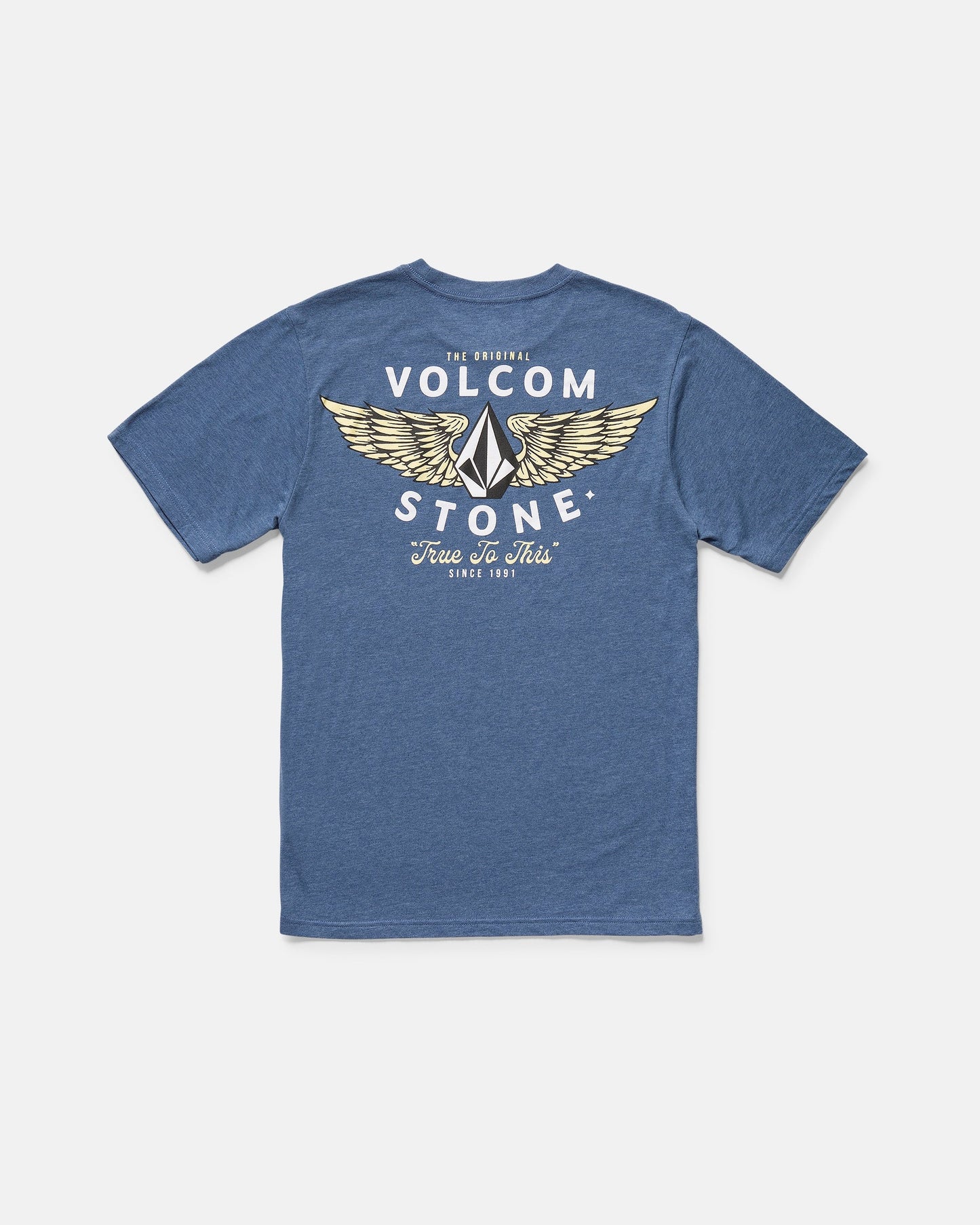 The Volcom Men's Hi Flyer Short Sleeve Tee is a blue modern fit shirt featuring a back graphic of yellow wings and bold "The Original Volcom Stone" and "True To This Since 1991" text in white and yellow.