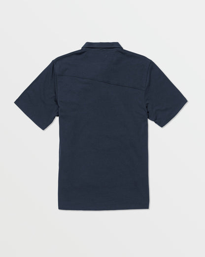 The Volcom Kids' Wowzer Polo Short Sleeve Tee is a navy blue modern fit shirt, shown from the back and laid flat on a white background. Made from a comfortable cotton-poly blend.