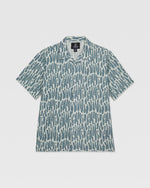 The Volcom Kids' Boldstone Short Sleeve Tee features a boxy fit, collar, and button-up front with an allover abstract blue and white brushstroke print. It's shown laid flat on a white background.