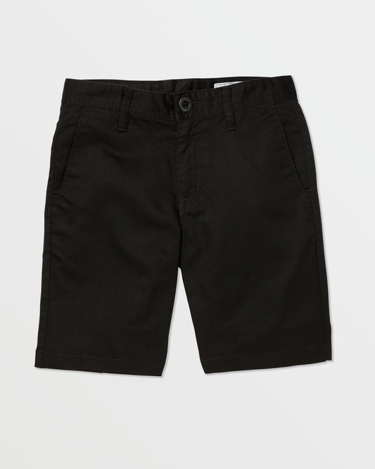 A pair of black Volcom Kids' Frickin Chino Shorts 16" with a modern fit, front pockets, belt loops, and a button closure is laid flat on a white background.
