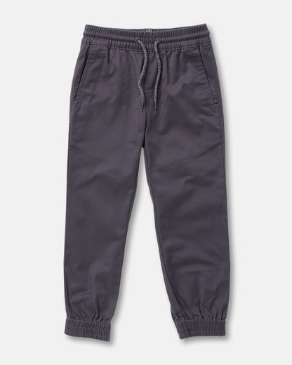 The Volcom Kids' Big Boys Frickin Slim Joggers in dark gray, made with recycled fibers, feature an elastic waist with drawstring, two side pockets, and elastic ankle cuffs; pants shown laid flat on a white background.
