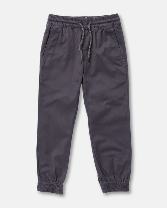 The Volcom Kids' Big Boys Frickin Slim Joggers in dark gray, made with recycled fibers, feature an elastic waist with drawstring, two side pockets, and elastic ankle cuffs; pants shown laid flat on a white background.