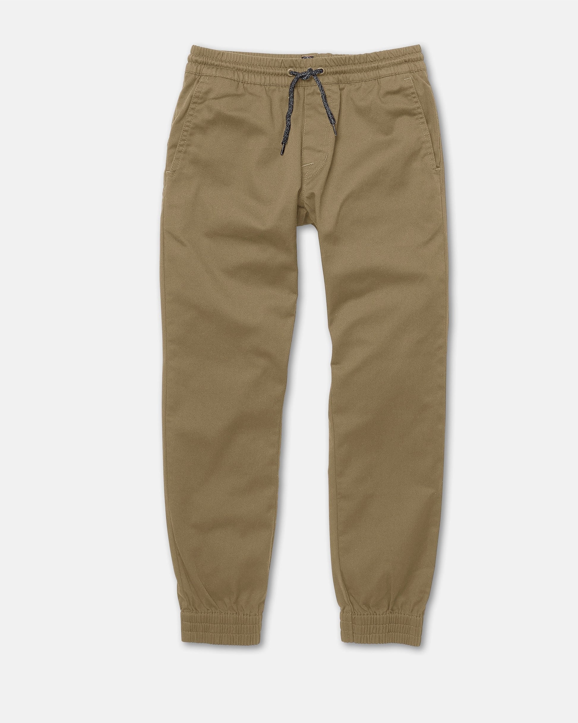Volcom Kids' Big Boys Frickin Slim Joggers in khaki, made with recycled fibers. Feature an elastic waistband, black drawstring, side pockets, and elastic cuffs at the ankles. Laid flat on a white background.