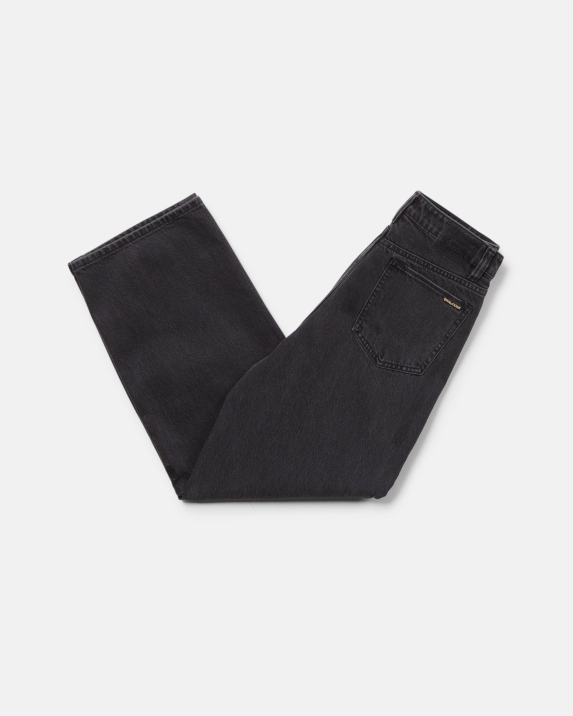 A pair of Volcom Boy's Big Boys' Billow Denim II Pants in black, folded neatly on a white background with the back pocket and waistband visible.