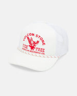 The Men's Shred Supply Trucker by Volcom is a white five-panel hat with mesh panels, curved brim, bold red VOLCOM STONE text, eagle graphic, "RIDE FREE AMERICAN BOARDING CO." on the front, and a red and white braided cord.