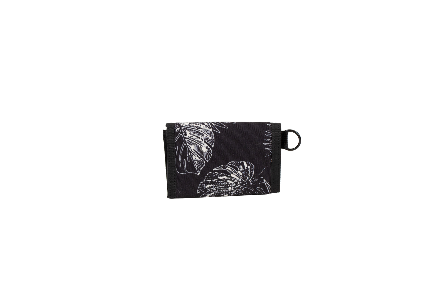 A black cotton canvas wallet with a white leaf and flower pattern, folded closed, featuring a small black loop on the right side, is displayed against a plain white background. The Men’s Box Stone Wallet from Volcom combines style and practicality in a compact design.