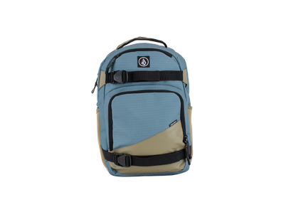 The Volcom Men's Grindstone Skate Backpack features a blue and khaki design with black straps and buckles, a small logo on the upper front, a top handle, ergonomic shoulder straps for comfortable carrying, and multiple compartments including a padded laptop sleeve.