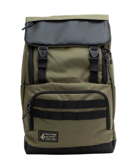 The Volcom Men's Charter Ruck Backpack in olive green and black features a top flap with two front buckles, a zippered front pocket, and a label patch at the bottom. This workwear-inspired backpack is designed with black straps and zipper pulls, offering a sturdy rectangular shape that’s perfect for everyday use or securely carrying your laptop.