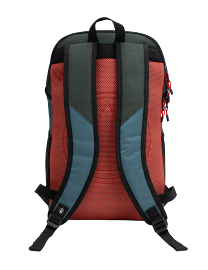The Volcom Men's Slam School Backpack is displayed from the back, featuring red padded straps, teal blue side panels, and a black top handle. The zippers are accented with red pull tabs. Designed for functionality, this backpack includes a spacious main compartment and a padded laptop sleeve to keep essentials organized and protected.