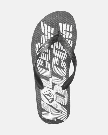 The Volcomotion Mens flip-flop by Volcom features a black textured sole, white abstract design, and VOLCOM branding on the strap and footbed.